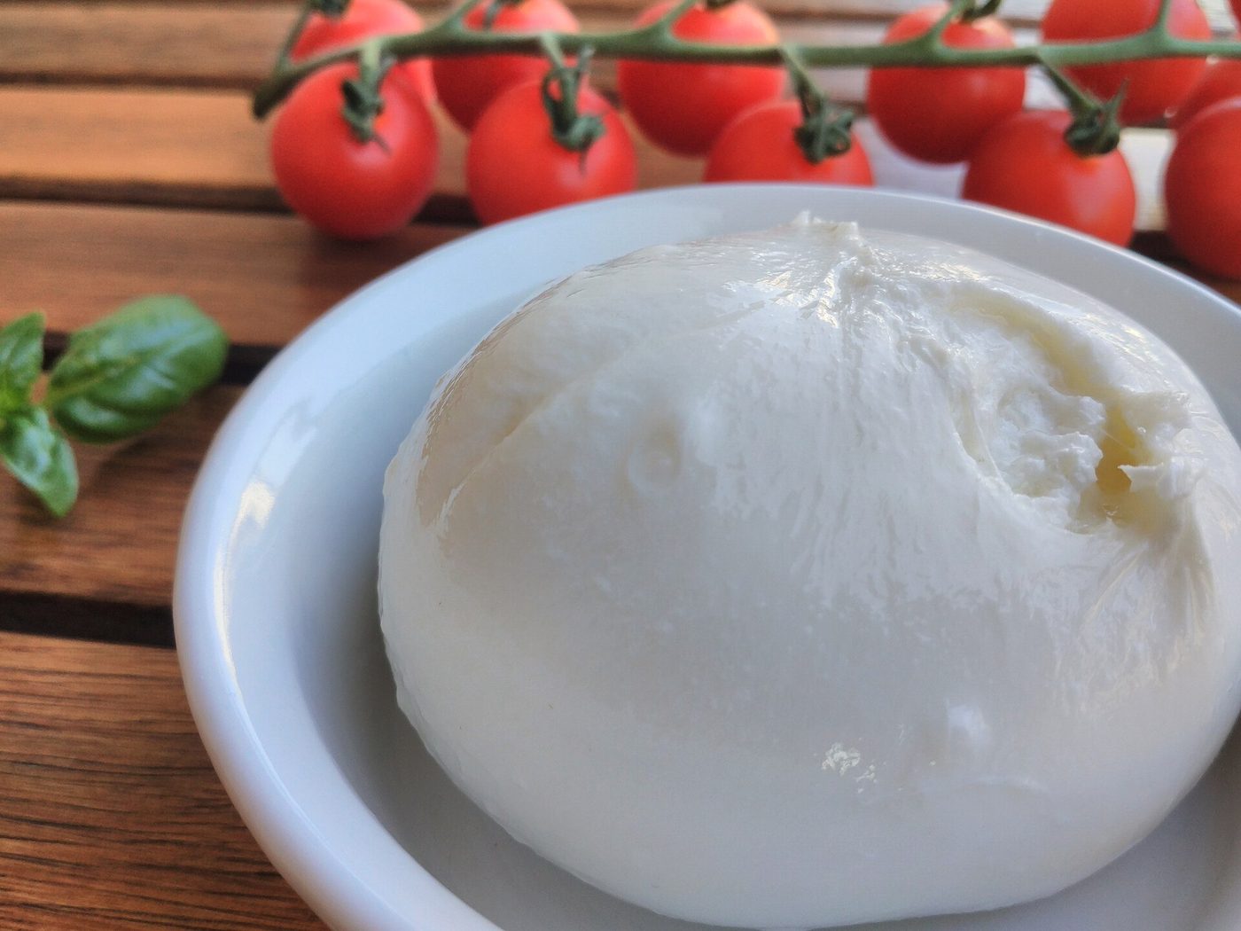 Una burrata pugliese servita con pomodorini e basilico